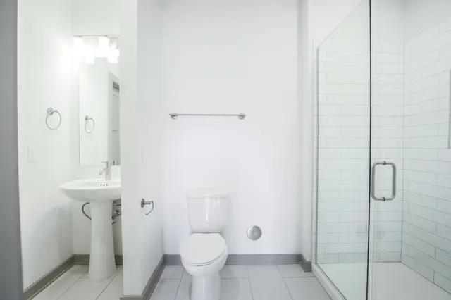 a bathroom with a sink a toilet and shower