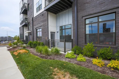 a view of a brick house many windows and flower plants