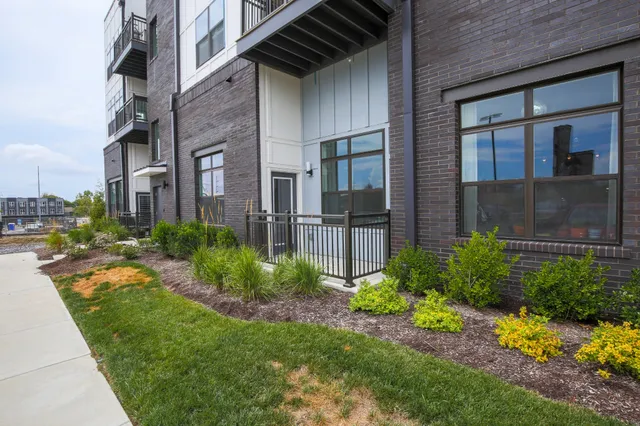 a view of a brick house many windows and flower plants