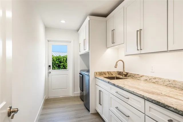 a kitchen with granite countertop white cabinets and a sink