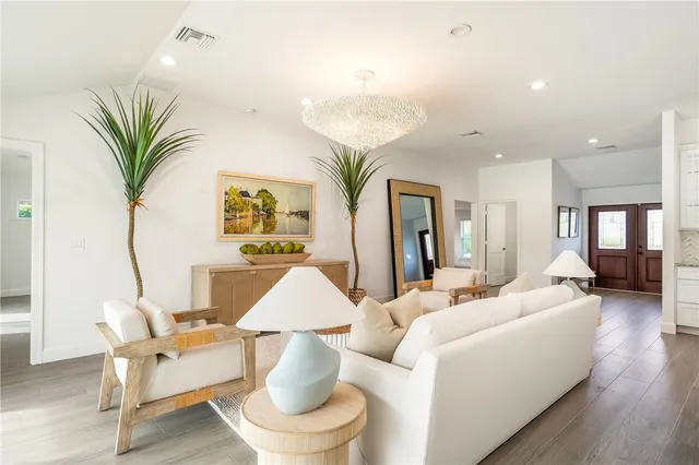 a living room with patio furniture and wooden floor