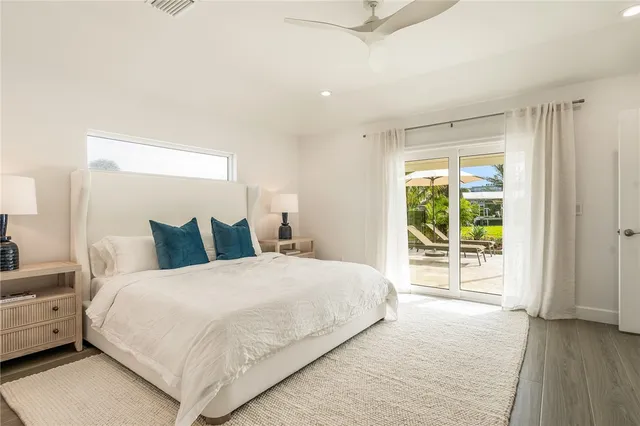 a view of a bedroom with cabinet mirror and windows