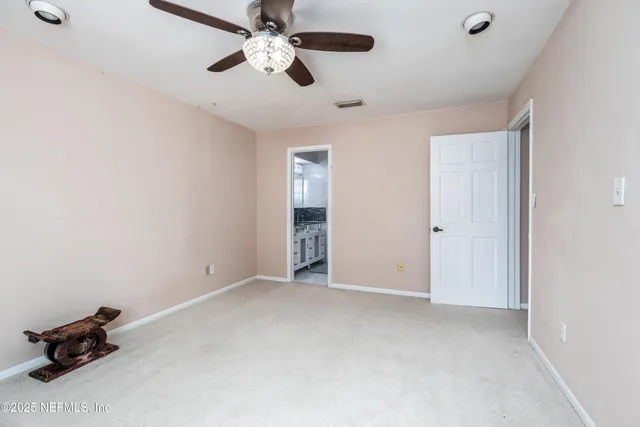 a view of an empty room with a ceiling fan