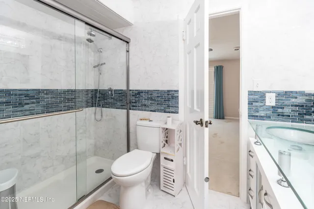 a bathroom with a sink a toilet and shower