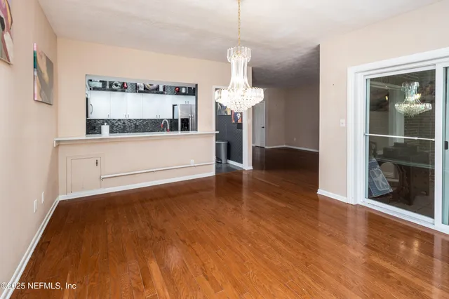 a view of a room with wooden floor and a chandelier
