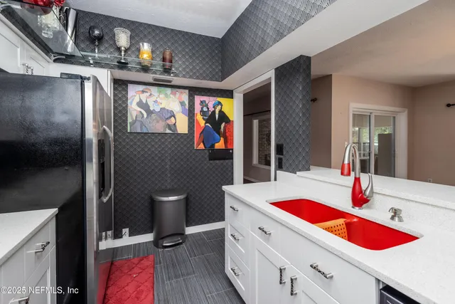 a kitchen with a sink dishwasher and a refrigerator with wooden floor