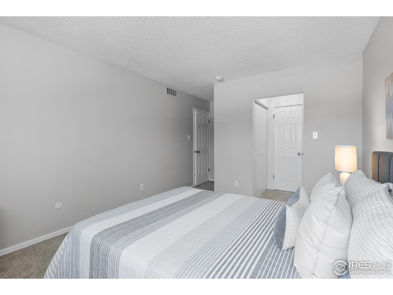 1170 Monroe Drive, Unit C Boulder, CO 80303 - Photo 9 of 14 a bedroom with a bed and a lamp