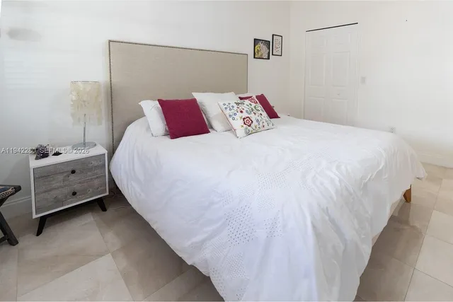 a bedroom with a bed and a night stand