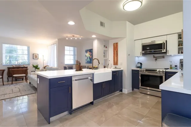 a large kitchen with stainless steel appliances and large windows