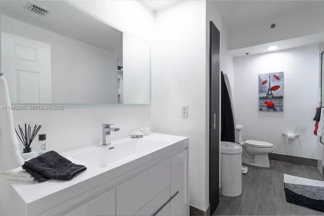 a bathroom with a toilet sink and mirror
