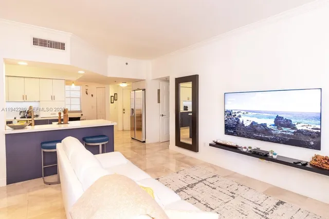 a living room with stainless steel appliances furniture a rug and a large window