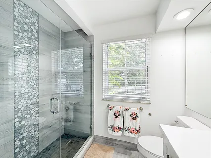 a white toilet sitting next to a bathroom sink