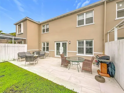 a view of a house with backyard and sitting area