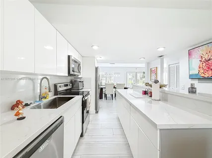 a large white kitchen with stainless steel appliances lots of counter top space
