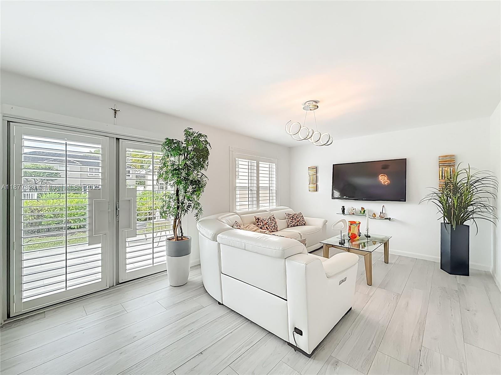 7110 Southwest 54th Street Miami, FL 33155 - Photo 9 of 40 a living room with furniture and a flat screen tv