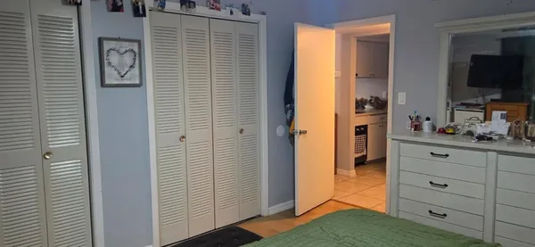 a view of bedroom with flat screen tv and dresser