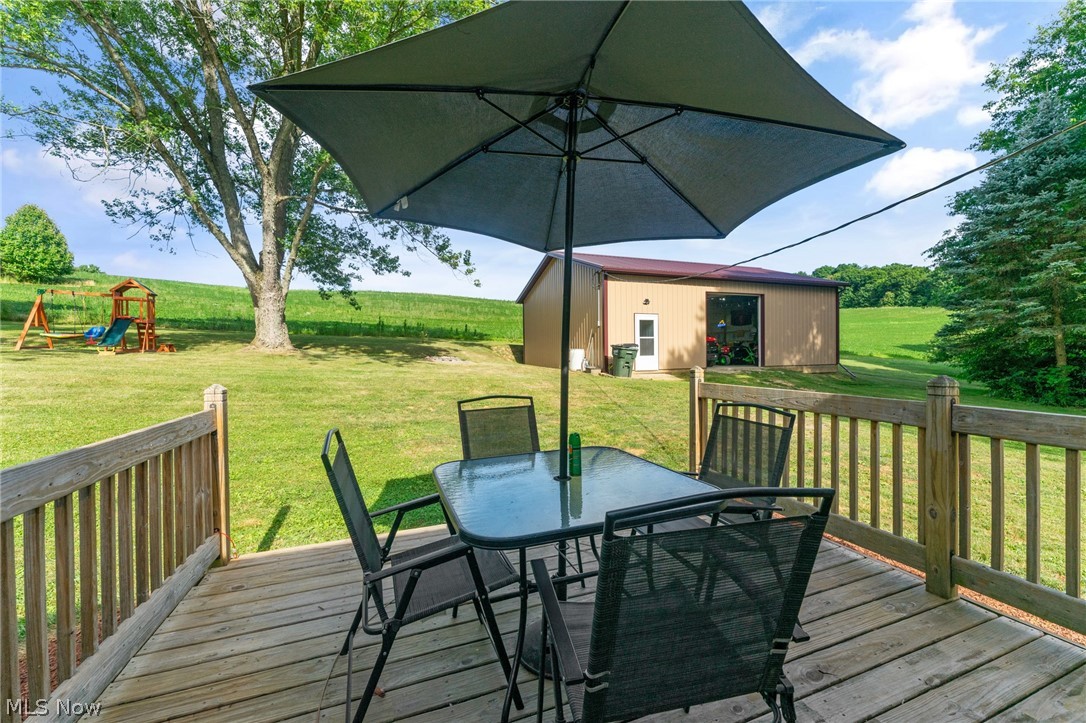 8184 Rochester Road East Rochester, OH 44625 - Photo 21 of 28 Wooden terrace featuring a playground, a lawn, and an outdoor structure