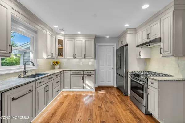 a kitchen with a sink stove top oven and refrigerator