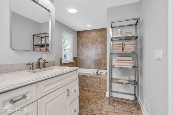 a spacious bathroom with a granite countertop sink and a mirror