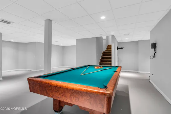 a room with pool table and stairs