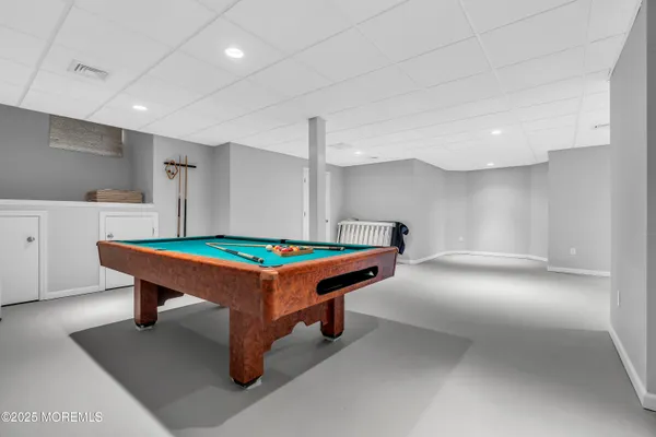 a room with pool table and windows