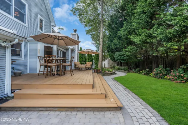 a view of a patio with a table and chairs under an umbrella