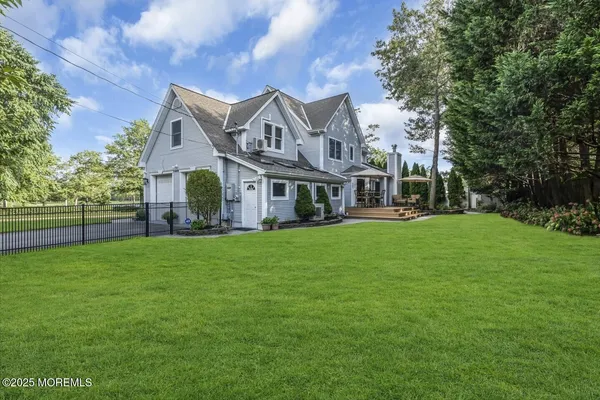 a view of a big house with a big yard and large trees