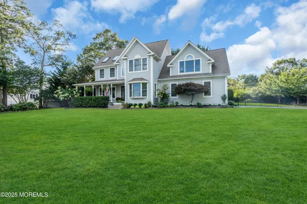 a front view of a house with garden and trees