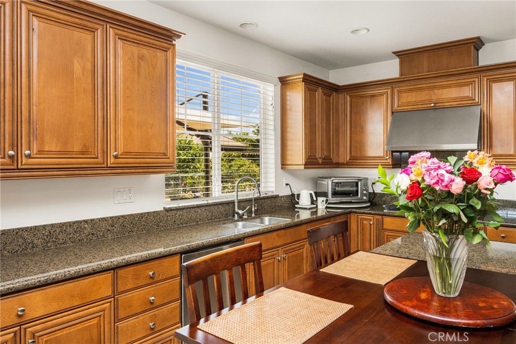 12652 Twin Peak Court Riverside, CA 92503 - Photo 12 of 55 a kitchen with stainless steel appliances granite countertop a sink dishwasher and cabinets with wooden floor