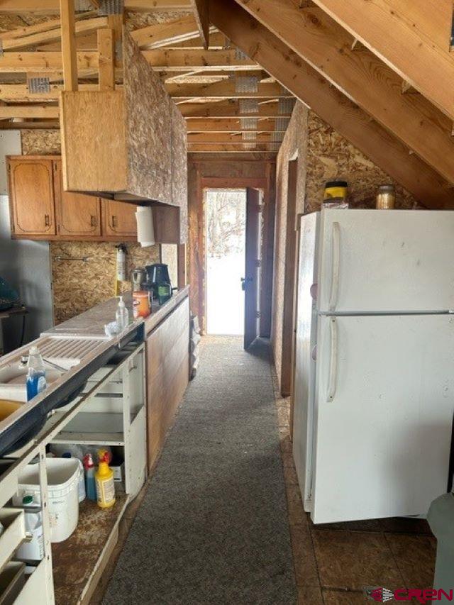 13 West Elk View Cedaredge, CO 81413 - Photo 5 of 31 a kitchen with a refrigerator and white cabinets