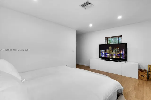 a bedroom with a bed and a flat screen tv