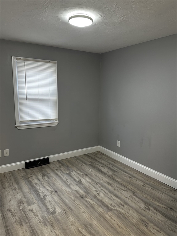 215 Belmont Avenue, Unit 1 Brockton, MA 02301 - Photo 13 of 30 an empty room with wooden floor and windows