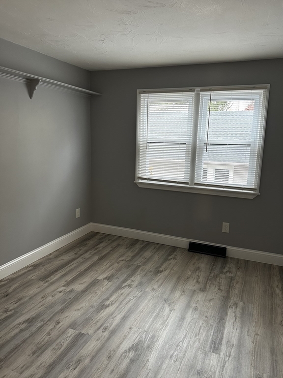 215 Belmont Avenue, Unit 1 Brockton, MA 02301 - Photo 14 of 30 an empty room with wooden floor and windows