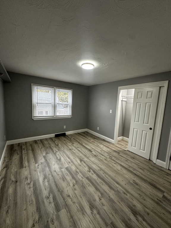 215 Belmont Avenue, Unit 1 Brockton, MA 02301 - Photo 17 of 30 a view of an empty room and window and wooden floor