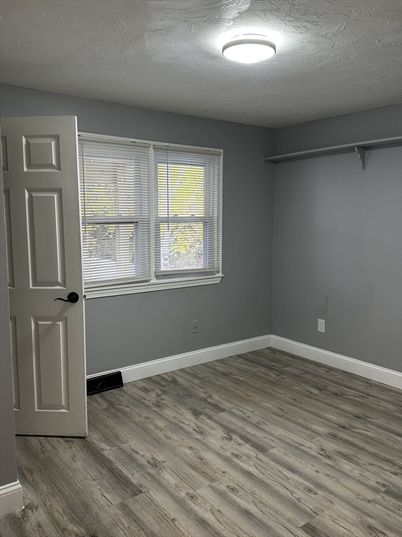 215 Belmont Avenue, Unit 1 Brockton, MA 02301 - Photo 18 of 30 an empty room with wooden floor and windows