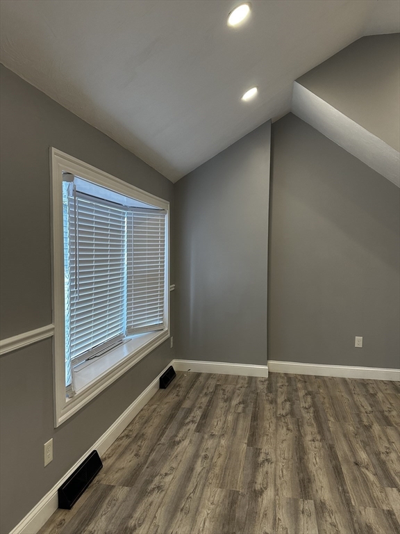 215 Belmont Avenue, Unit 1 Brockton, MA 02301 - Photo 5 of 30 a view of an empty room with wooden floor and a window