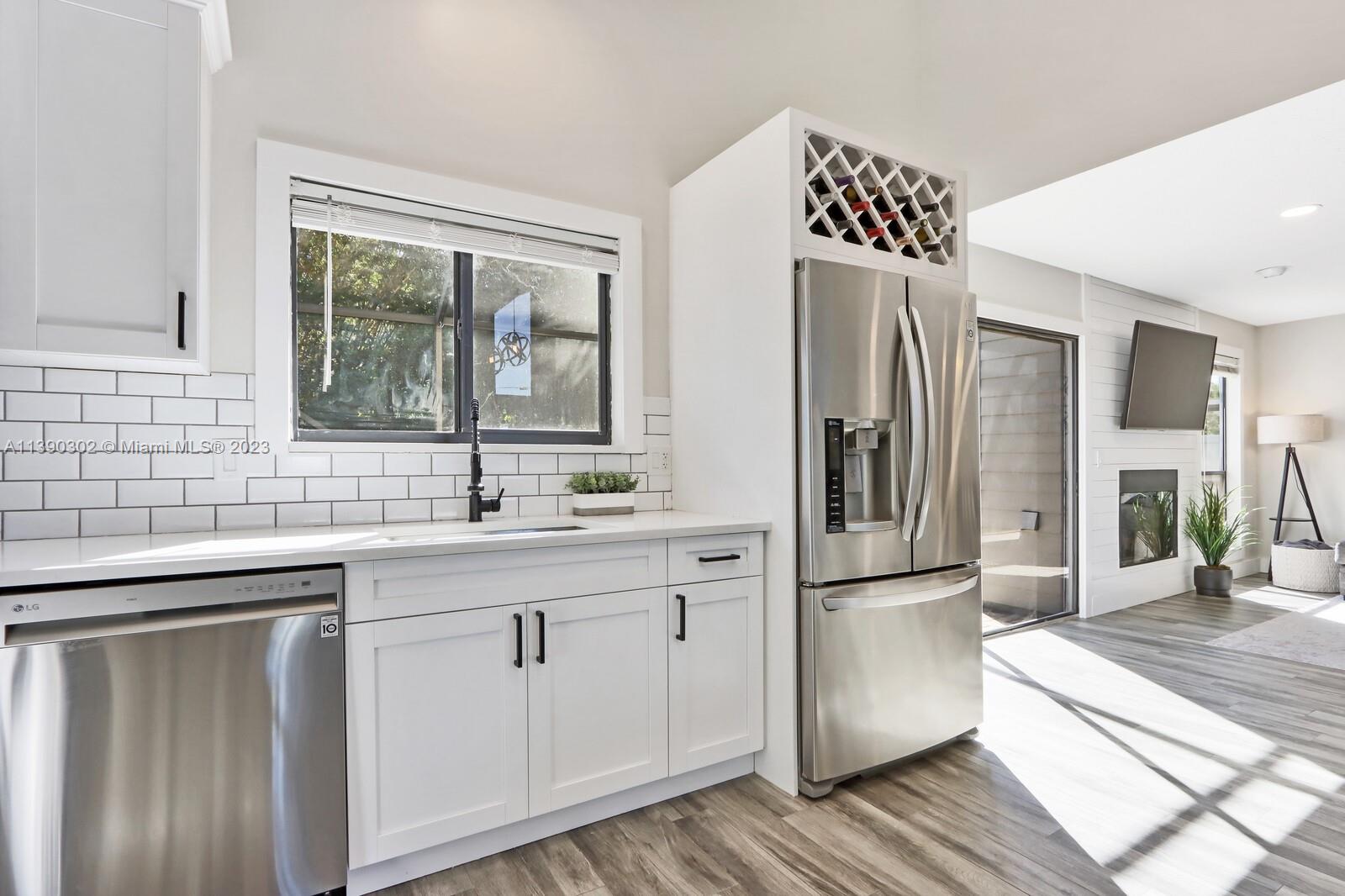 6122 Adams Street Jupiter, FL 33458 - Photo 14 of 59 a kitchen with stainless steel appliances a sink cabinets and wooden floor