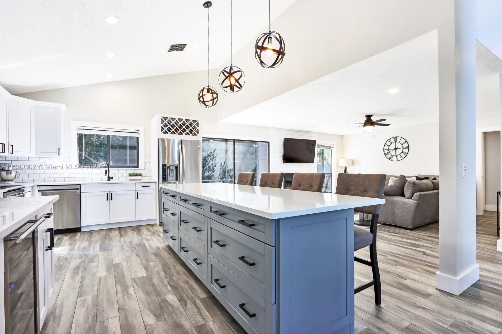 6122 Adams Street Jupiter, FL 33458 - Photo 15 of 59 a large kitchen with a lot of counter space and wooden floor