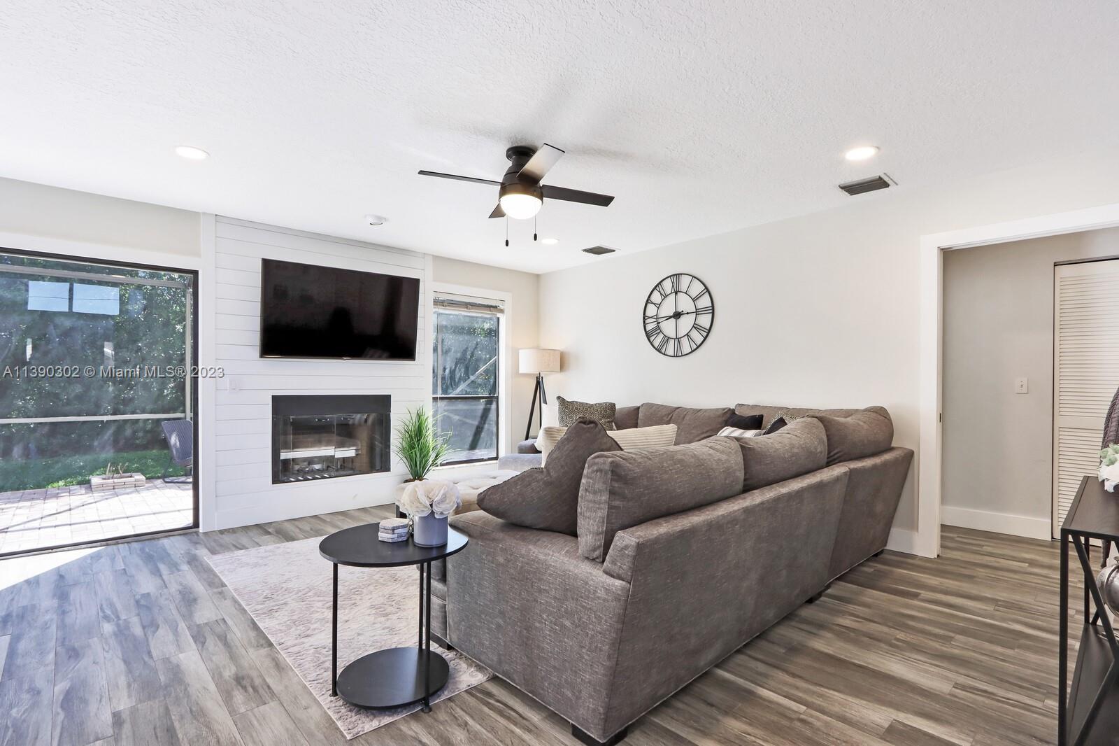 6122 Adams Street Jupiter, FL 33458 - Photo 17 of 59 a living room with furniture and a fireplace