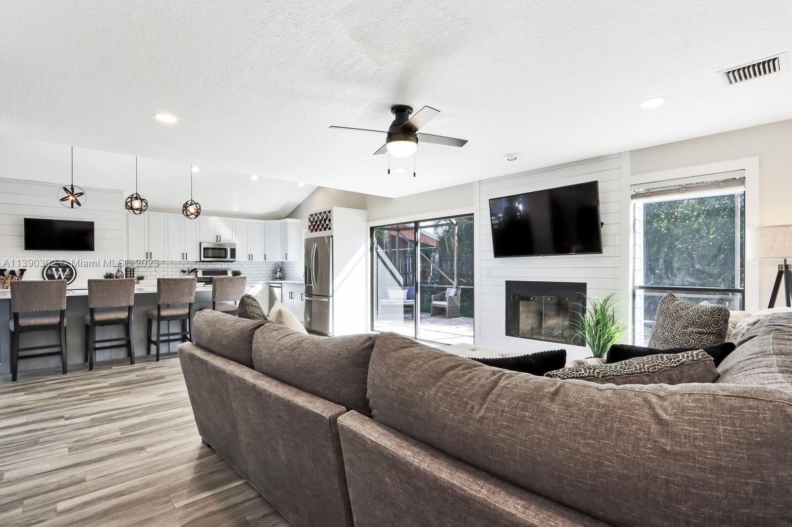 6122 Adams Street Jupiter, FL 33458 - Photo 18 of 59 a living room with furniture fireplace and flat screen tv