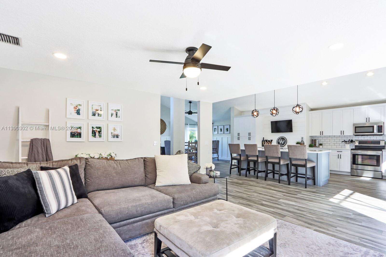 6122 Adams Street Jupiter, FL 33458 - Photo 19 of 59 a living room with furniture kitchen view and a wooden floor