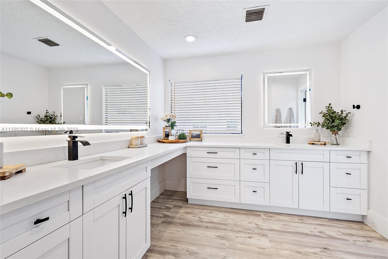 6122 Adams Street Jupiter, FL 33458 - Photo 24 of 59 a spacious bathroom with double sink a a window and a mirror