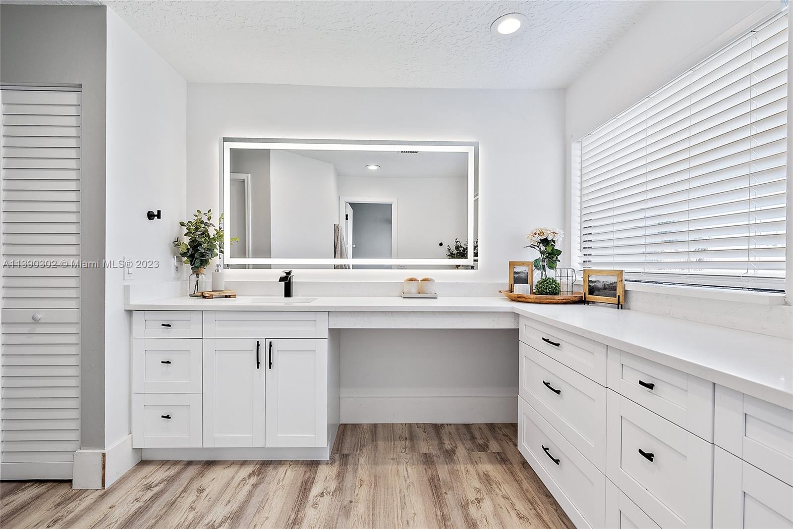 6122 Adams Street Jupiter, FL 33458 - Photo 25 of 59 a spacious bathroom with a double vanity sink and a mirror