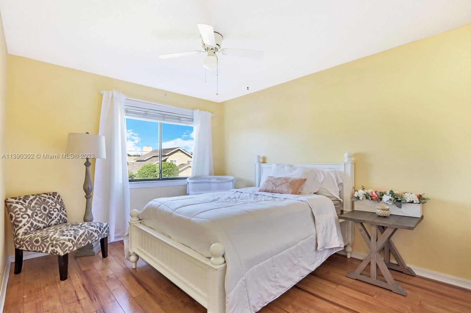 6122 Adams Street Jupiter, FL 33458 - Photo 27 of 59 a bed sitting in a bedroom next to a window