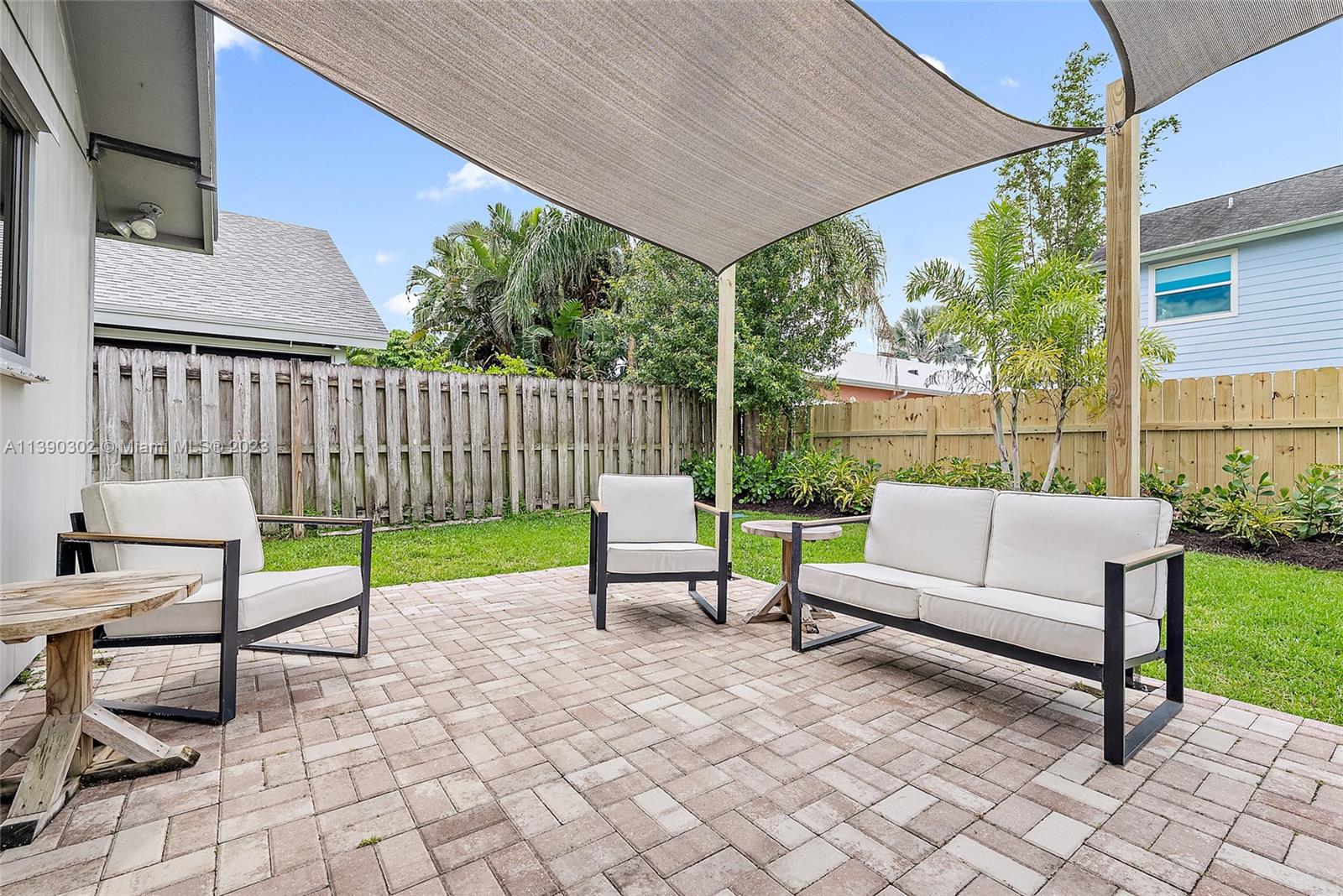 6122 Adams Street Jupiter, FL 33458 - Photo 30 of 59 a view of a chair and tables in the back yard of the house