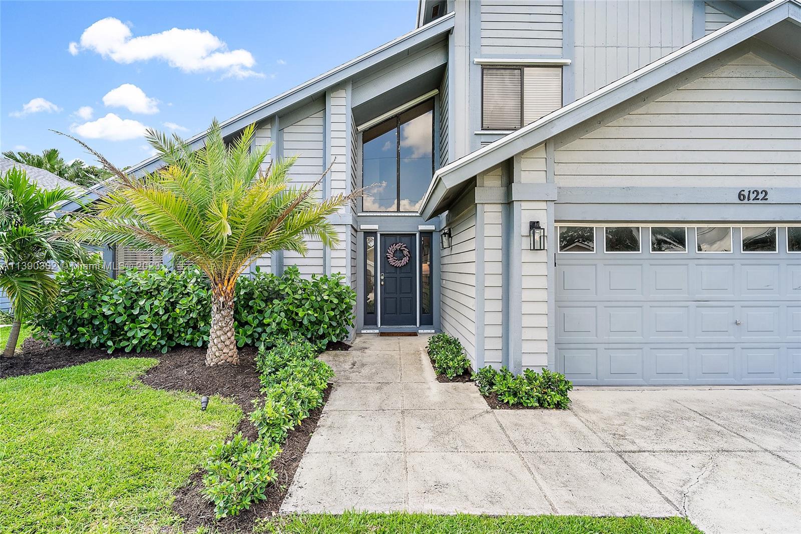 6122 Adams Street Jupiter, FL 33458 - Photo 3 of 59 a front view of a house with a yard
