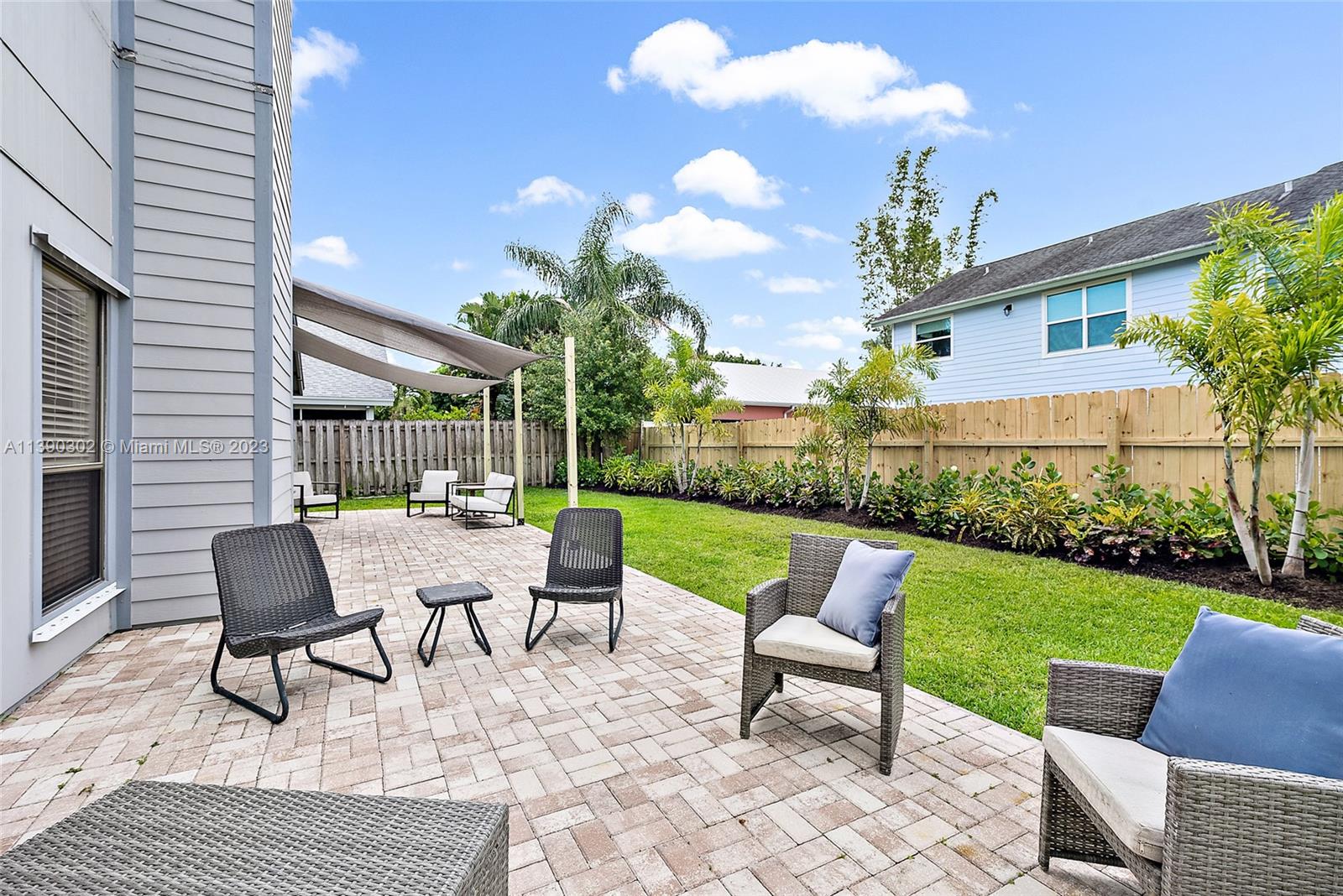 6122 Adams Street Jupiter, FL 33458 - Photo 31 of 59 a view of a patio with couches potted plants and a big yard