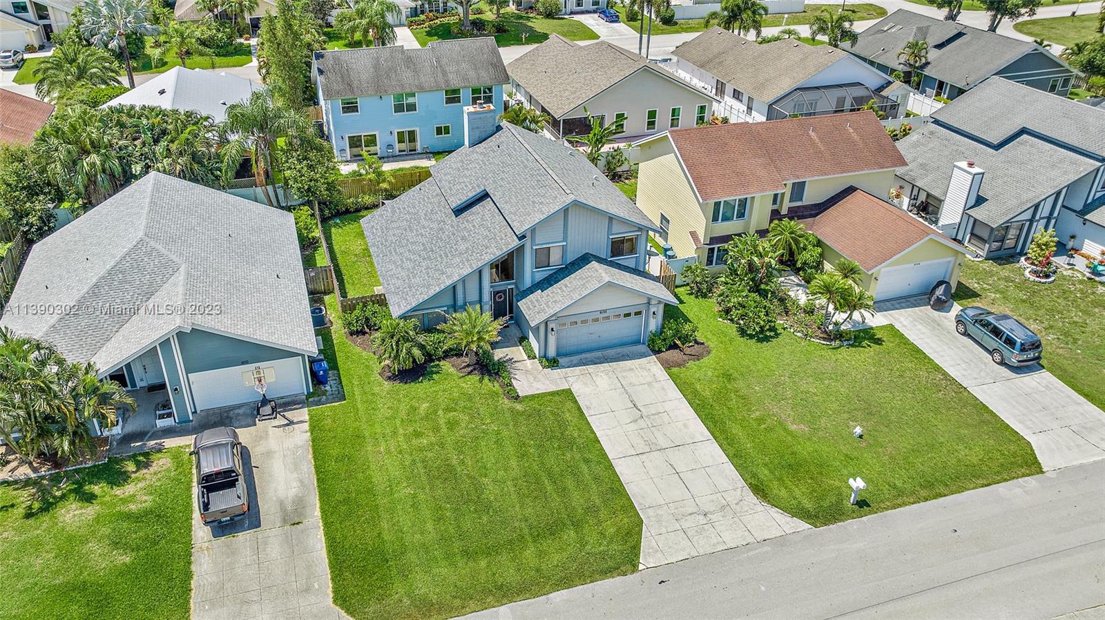 6122 Adams Street Jupiter, FL 33458 - Photo 34 of 59 an aerial view of a house with a garden and swimming pool