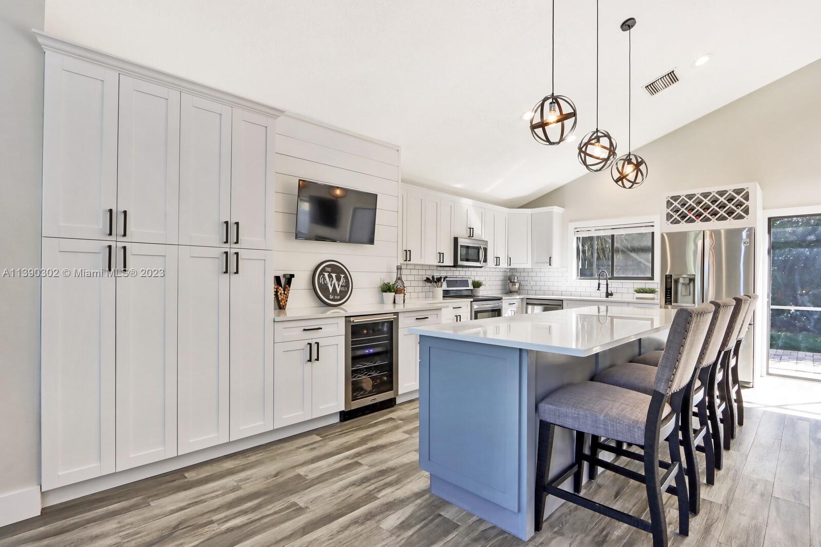 6122 Adams Street Jupiter, FL 33458 - Photo 9 of 59 a kitchen with stainless steel appliances a stove a sink cabinets and a refrigerator