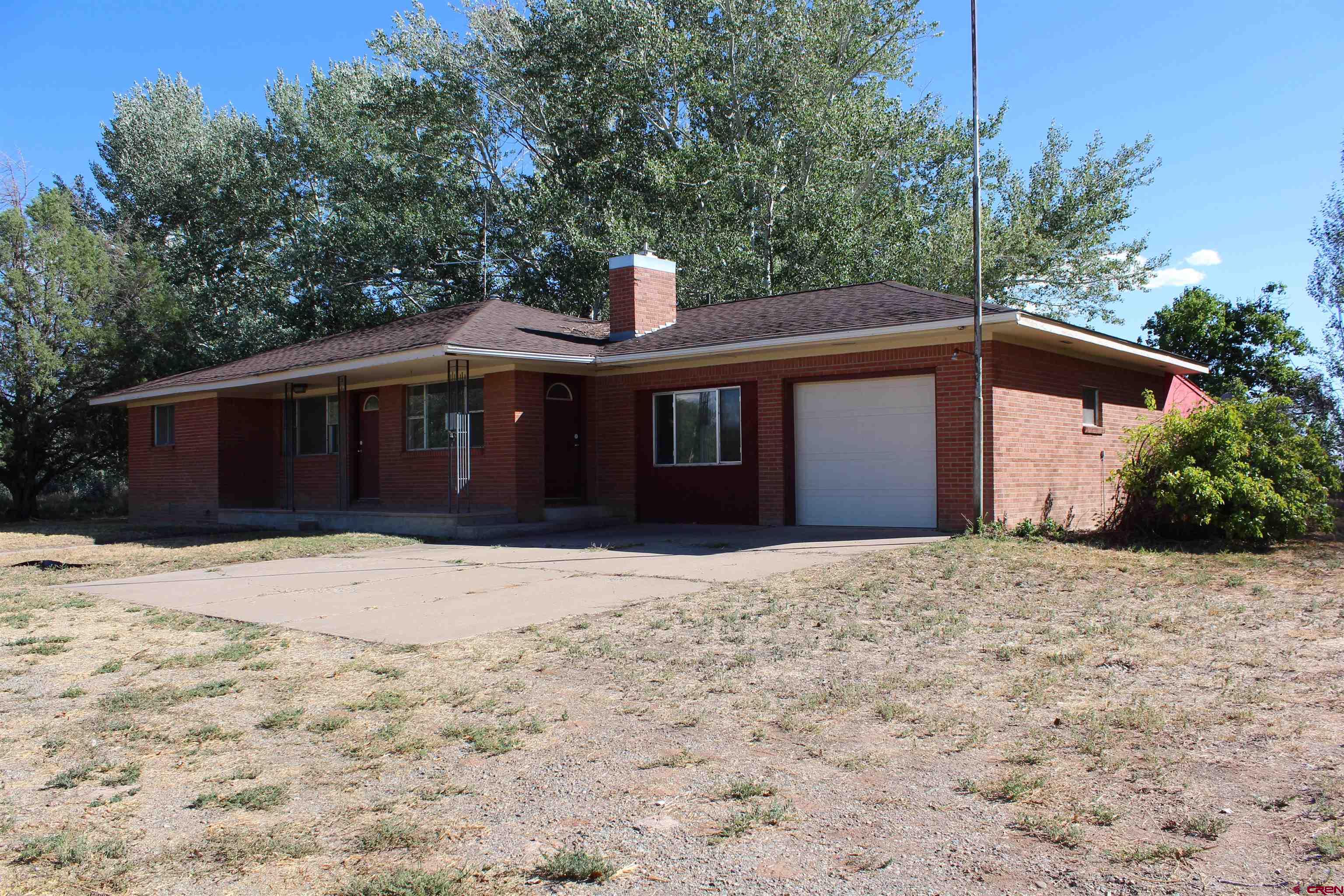 23892 County Rd M Cortez, CO 81321 - Photo 1 of 27 a front view of house with yard and trees around